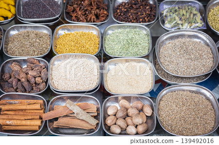 Assortment of spices and seeds, top view. Different seasonings, spices in the metal plates Assortment of spices and seeds, top view. Different seasonings, spices in the metal plates 139492016