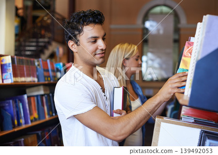Student, book and man in a library to search at university, college or school campus for education. Bookshelf, learning or male person with scholarship studying knowledge, research and information Student, book and man in a library to search at university, college or school campus for education. Bookshelf, learning or male person with scholarship studying knowledge, research and information 139492053