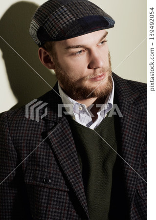 Fashion, thinking and young man in a studio with classy, elegant and fancy retro outfit and hat. Serious, handsome and male person from Australia with vintage style and accessory by gray background. Fashion, thinking and young man in a studio with classy, elegant and fancy retro outfit and hat. Serious, handsome and male person from Australia with vintage style and accessory by gray background. 139492054