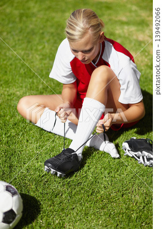 Girl, soccer and tie shoelace on field, safety and start training for fitness, health or competition on pitch. Person, shoes and football for preparation, ready or game for sport contest on grass Girl, soccer and tie shoelace on field, safety and start training for fitness, health or competition on pitch. Person, shoes and football for preparation, ready or game for sport contest on grass 139492066