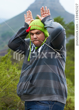 Mountain, funny hat and portrait of man in nature for camping, hiking and adventure outdoors. Comic, humor and person with bunny ears for joke on holiday, vacation and explore to travel wilderness Mountain, funny hat and portrait of man in nature for camping, hiking and adventure outdoors. Comic, humor and person with bunny ears for joke on holiday, vacation and explore to travel wilderness 139492327