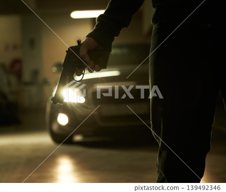 Person, hand and gun for car hijack in parking lot for victim abduction for ransom, robbery or scary violence. Gangster mafia, pistol weapon and vehicle at night for danger revenge, crime or threat Person, hand and gun for car hijack in parking lot for victim abduction for ransom, robbery or scary violence. Gangster mafia, pistol weapon and vehicle at night for danger revenge, crime or threat 139492346