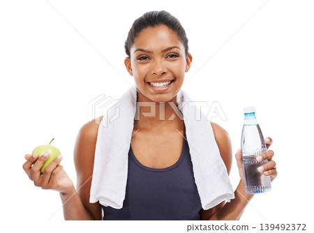 Portrait, apple and water for fitness with a woman in studio isolated on a white background for health. Exercise, smile and towel with a confident young athlete at the gym for training or nutrition Portrait, apple and water for fitness with a woman in studio isolated on a white background for health. Exercise, smile and towel with a confident young athlete at the gym for training or nutrition 139492372