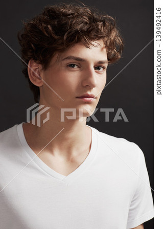 Young man, portrait and serious with model, casual fashion and gen z style with confidence in studio. Youth, hipster and male person with cool, trendy and minimalist clothes with black background 139492416