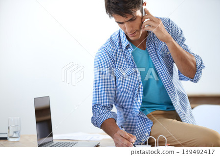Businessman, phone call and writing with laptop for networking, communication or planning with documents. Person, smartphone and paperwork with technology for entrepreneur and discussion at workplace 139492417