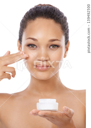 Young woman, portrait and beauty cream, skincare and cosmetics on a white background. Face of an African model or person with moisturizer application, skin care product and dermatology in studio Young woman, portrait and beauty cream, skincare and cosmetics on a white background. Face of an African model or person with moisturizer application, skin care product and dermatology in studio 139492500