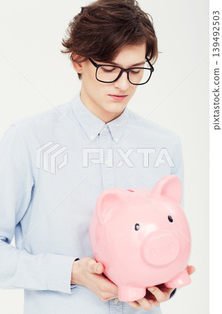 Piggy bank, thinking and man with finance, business and planning isolated on a white studio background. Person, model and entrepreneur with savings, transactions and investment with payment and ideas Piggy bank, thinking and man with finance, business and planning isolated on a white studio background. Person, model and entrepreneur with savings, transactions and investment with payment and ideas 139492503