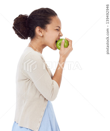 Woman, eating apple and healthy food choice for detox, dental health and wellness on a white background. Profile of a young person biting a green fruit for nutrition, strong teeth or vegan in studio Woman, eating apple and healthy food choice for detox, dental health and wellness on a white background. Profile of a young person biting a green fruit for nutrition, strong teeth or vegan in studio 139492946