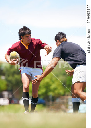 Rugby player, game and tackle on a field during competitive sport match outdoors. Teamwork, training and playing professional athletic exercise in uniform to avoid person outdoor for practice Rugby player, game and tackle on a field during competitive sport match outdoors. Teamwork, training and playing professional athletic exercise in uniform to avoid person outdoor for practice 139493125