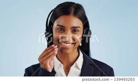 Happy woman, portrait and headphones for call center or customer service against a blue studio background. Face of female person, consultant or agent smile with mic for online advice on mockup space Happy woman, portrait and headphones for call center or customer service against a blue studio background. Face of female person, consultant or agent smile with mic for online advice on mockup space 139493203