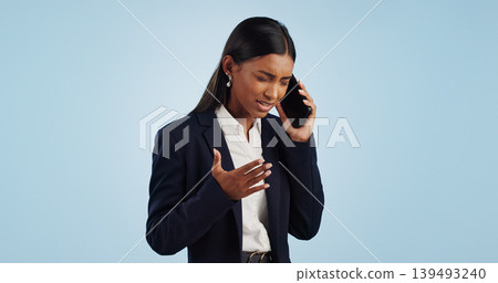 Business, phone call and woman with stress, angry and employee isolated on a blue studio background. Mockup space, person and entrepreneur with a smartphone, connection and frustrated with emotions Business, phone call and woman with stress, angry and employee isolated on a blue studio background. Mockup space, person and entrepreneur with a smartphone, connection and frustrated with emotions 139493240
