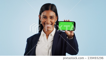 Happy business woman, phone and green screen for advertising against a blue studio background. Portrait of female person or employee smile showing mobile smartphone display, chromakey or mockup space Happy business woman, phone and green screen for advertising against a blue studio background. Portrait of female person or employee smile showing mobile smartphone display, chromakey or mockup space 139493296
