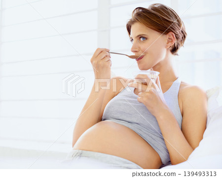 Breakfast in bed, eating and pregnant woman with chocolate pudding in a house, calm and hungry. Sugar, face and female person in bedroom with pregnancy nutrition for health, balance or utero wellness Breakfast in bed, eating and pregnant woman with chocolate pudding in a house, calm and hungry. Sugar, face and female person in bedroom with pregnancy nutrition for health, balance or utero wellness 139493313