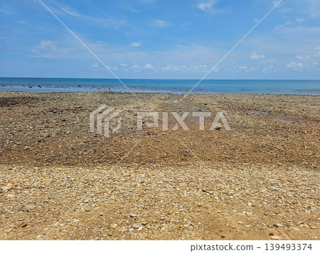Wide Angle View of Pebble Stone Beach and Calm Blue Sea Under Clear Sky 139493374