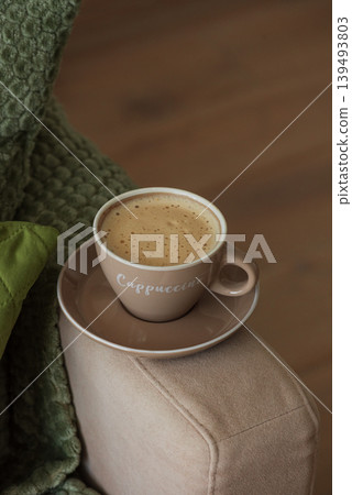 Cup of Hot Coffee Stay on Arm of Cozy Couch by Blanket Cup of Hot Coffee Stay on Arm of Cozy Couch by Blanket 139493803