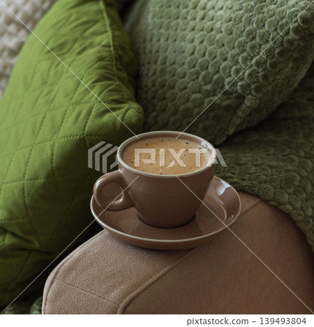 Cup of Hot Coffee Stay on Arm of Cozy Couch by Blanket Cup of Hot Coffee Stay on Arm of Cozy Couch by Blanket 139493804