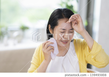 一位四十多歲的婦女擦了擦額頭的汗。 一位四十多歲的婦女擦了擦額頭的汗。 139493808