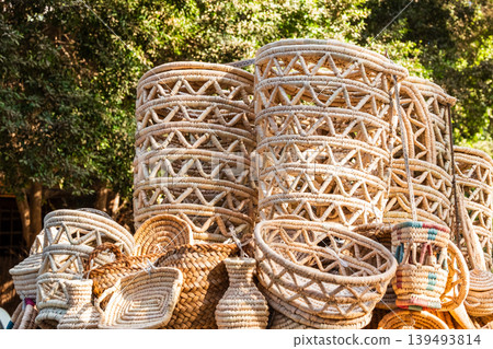 Traditional woven baskets made from palm leaves in Egypt. Various shapes and sizes are displayed, showcasing intricate craftsmanship and natural materials. 139493814
