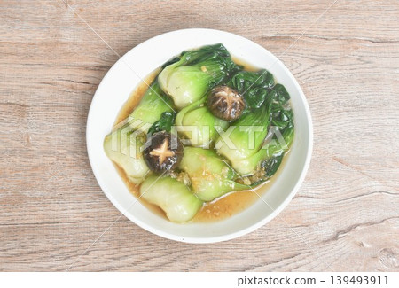 stir fried Chinese cabbage or Bok Choy topping black mushroom in gravy soy sauce on plate stir fried Chinese cabbage or Bok Choy topping black mushroom in gravy soy sauce on plate 139493911