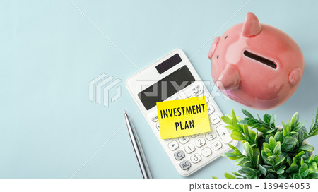 Pink piggy bank with investment plan note and calculator on blue background, financial strategy, wealth management, top view Pink piggy bank with investment plan note and calculator on blue background, financial strategy, wealth management, top view 139494053