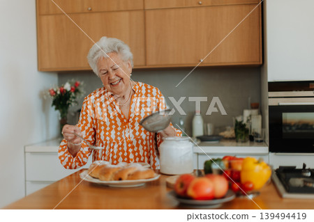 Happy senior woman with homemade easter braided bread with raisins. Close-up. Happy senior woman with homemade easter braided bread with raisins. Close-up. 139494419