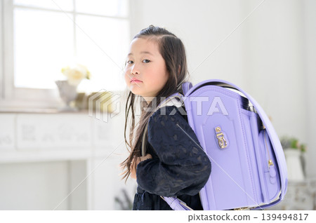 A Japanese girl turns around with her schoolbag on her back. A Japanese girl turns around with her schoolbag on her back. 139494817