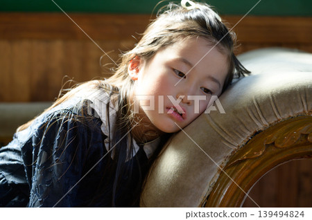 A Japanese girl leaning back on a sofa A Japanese girl leaning back on a sofa 139494824