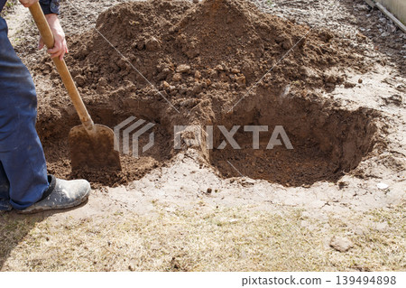 man digging a hole for planting a fruit tree in the garden 139494898