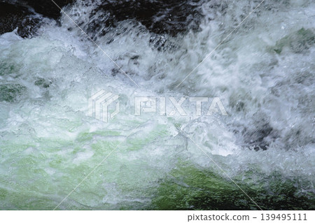 湍急的河水濺起的水花和白色泡沫。 湍急的河水濺起的水花和白色泡沫。 139495111