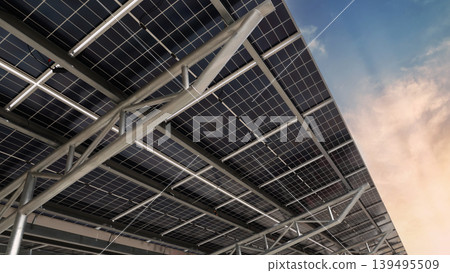 Solar panel car park roof. Low angle shot of Solar panel carport roof with steel structure generating clean renewable energy. Sustainable parking canopy with photovoltaic cells for eco power energy. Solar panel car park roof. Low angle shot of Solar panel carport roof with steel structure generating clean renewable energy. Sustainable parking canopy with photovoltaic cells for eco power energy. 139495509