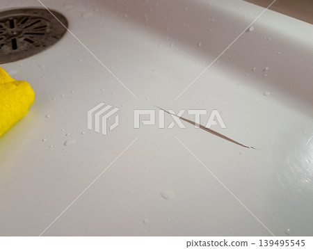Cracked Acrylic Bathtub with Yellow Cleaning Cloth 139495545