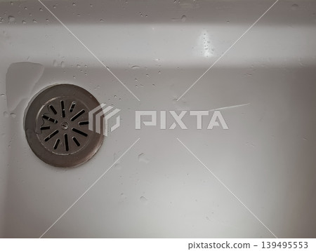 Bathroom Drain with Water Drops in White Sink Bathroom Drain with Water Drops in White Sink 139495553