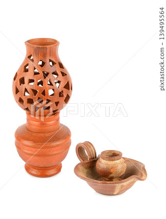 Handcrafted clay lamp and ceramic candlestick on white background 139495564