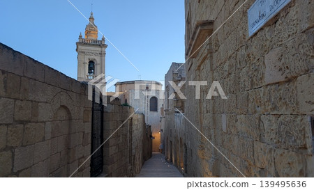 A view from a narrow slope with stone brick walls both sides in the old city of Gozo  139495636