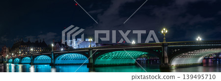 The arched river crossing shows historic structure detail, water reflections, and city background with clear night illumination. The arched river crossing shows historic structure detail, water reflections, and city background with clear night illumination. 139495710