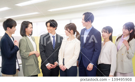 Young business professionals, a man and a woman, chatting and laughing in a bright workplace. Young business professionals, a man and a woman, chatting and laughing in a bright workplace. 139495908