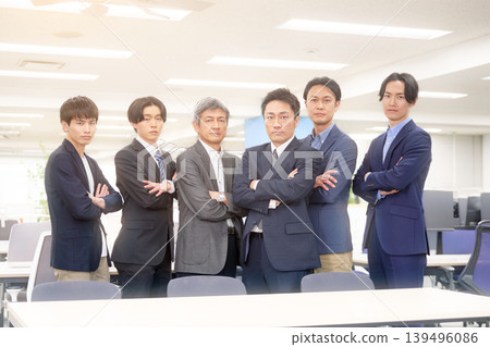 A trustworthy team of male businessmen standing side by side with their arms crossed. A trustworthy team of male businessmen standing side by side with their arms crossed. 139496086