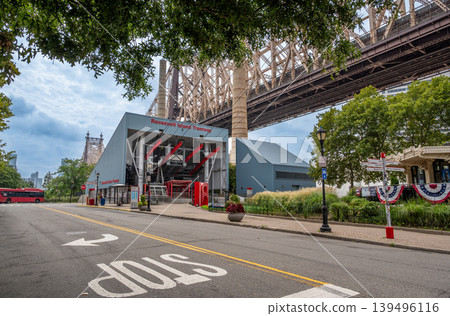 New york, usa august 17,2024. Roosevelt island tramway station and pedestrians on the street below the queensboro bridge, capturing new york city urban life New york, usa august 17,2024. Roosevelt island tramway station and pedestrians on the street below the queensboro bridge, capturing new york city urban life 139496116