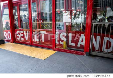 New york, usa august 17,2024. Roosevelt island tram car at station with passengers visible through glass windows, red exterior reading roosevelt island 139496133