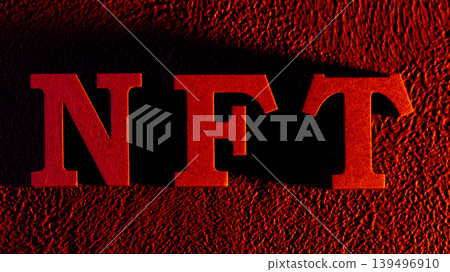 Red NFT letters with metallic texture on black textured background for crypto art concept 139496910