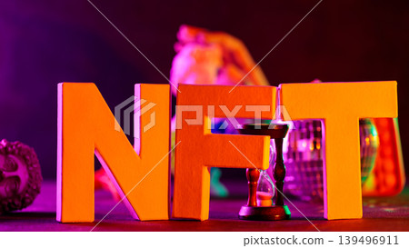 NFT letters with hourglass and classical sculpture illuminated by neon multicolor lighting NFT letters with hourglass and classical sculpture illuminated by neon multicolor lighting 139496911