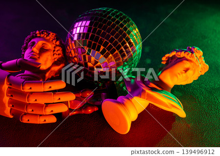 Disco ball with classical sculpture busts mannequin hands and colorful neon gradient lighting composition Disco ball with classical sculpture busts mannequin hands and colorful neon gradient lighting composition 139496912
