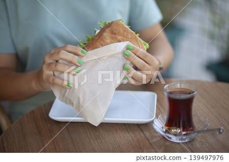 Woman Holding Sandwich. Casual Lunch with Sandwich in Woman Hand. Woman Holding Sandwich. Casual Lunch with Sandwich in Woman Hand. 139497976