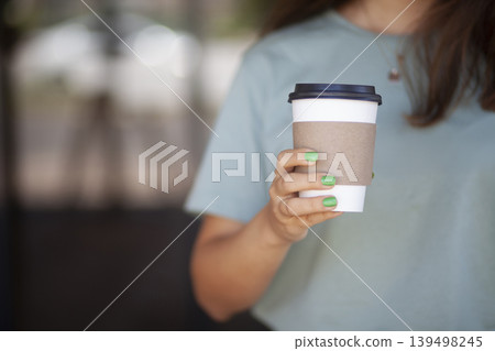 Woman Holding Takeaway Coffee Cup. Young Woman with Takeaway Coffee in Hand. Woman Holding Takeaway Coffee Cup. Young Woman with Takeaway Coffee in Hand. 139498245