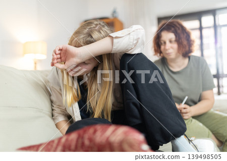 Young girl covering face during psychological therapy session Young girl covering face during psychological therapy session 139498505