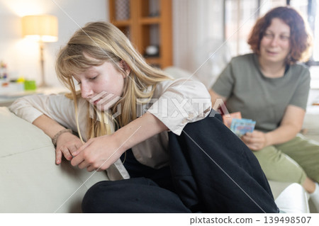 Teen girl feeling sad about money issues with mother Teen girl feeling sad about money issues with mother 139498507