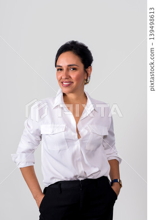 A woman in a white shirt and black pants is smiling for the camera 139498613