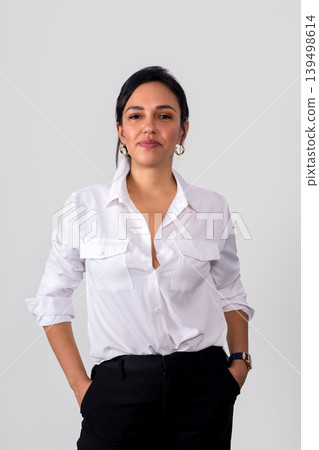 A woman in a white shirt and black pants is posing for a photo 139498614