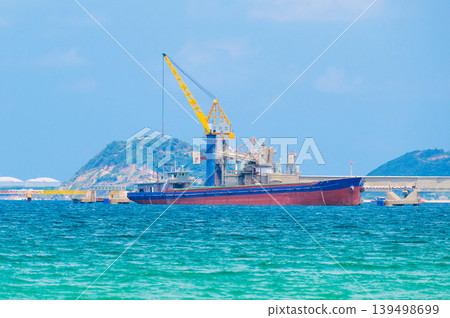 cargo ship is loading at port at sea. The industry of transportation and shipping for export by sea cargo ship is loading at port at sea. The industry of transportation and shipping for export by sea 139498699