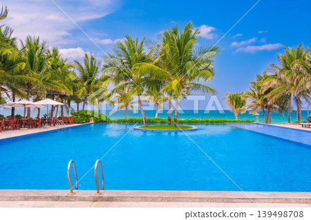 infinity swimming pool on the beach with palm trees by sea in a luxury hotel in resort in the tropics in Asia in summer infinity swimming pool on the beach with palm trees by sea in a luxury hotel in resort in the tropics in Asia in summer 139498708